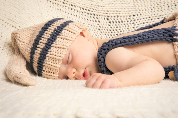 Adorable baby boy sleeping peacefully at home in the living room