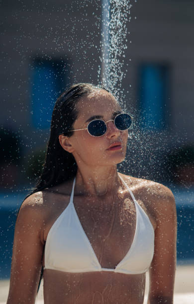 istock Young woman takes a shower on beach. 1356813601