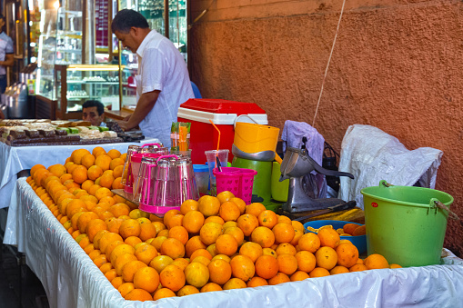MARRAKESH, MOROCCO - JUNE 04, 2017: Sale of fresh orange juice in the medina of Marrakesh on a sunny day.