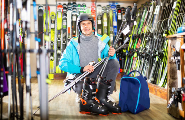 istock smiling man choose skis, helmet, boots and poles 1356814972
