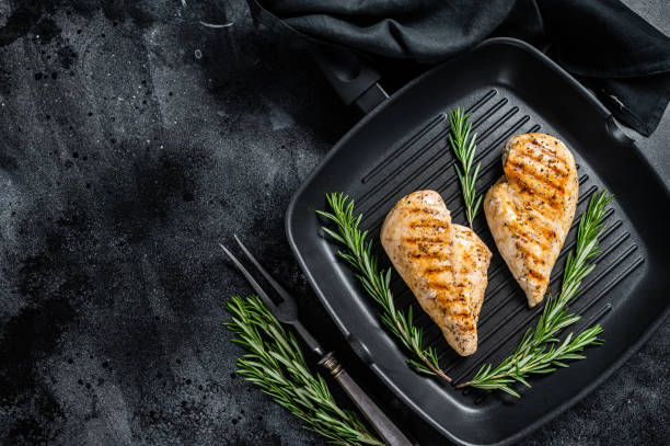 istock Grilled healthy chicken breasts cooked on a grill pan. Black background. Top view. Copy space 1356815169