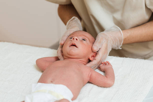 istock Physiotherapist doing a positional plagiocephaly correction on a newborn baby in a therapy center. 1356816118