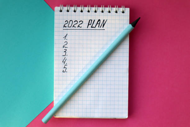 istock 2022 notebook mockup on pink background. New Year. Plans, goals for 2022 1356816307