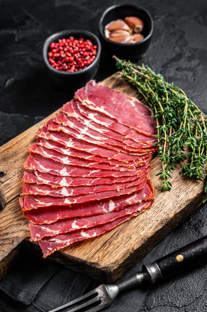 istock Sliced Turkish bacon Pastrami, roasted beef meat. Black background. Top view 1356816379