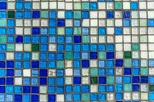 Background of grey and turquoise rectangular tiles of different texture