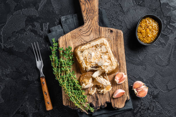 istock Aspic with chicken meat on wooden board. Black background. Top view 1356817920