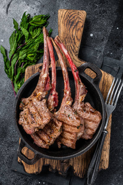 istock BBq Grilled lamb mutton chops steaks in a pan. Black background. Top view 1356822591