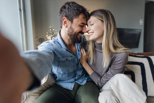 istock Personal perspective on a young couple taking a selfie at home 1356822661