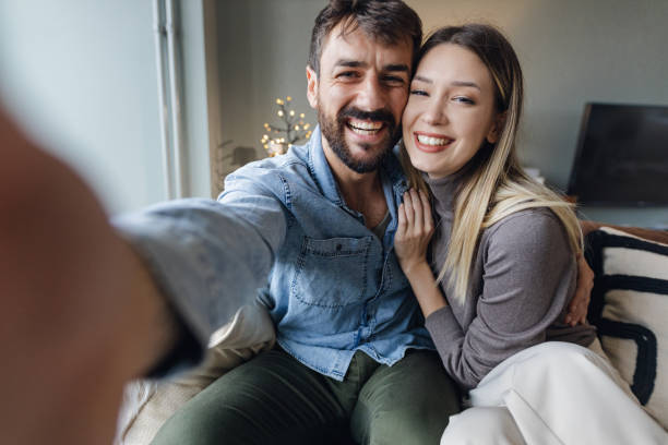 istock Personal perspective on a young couple taking a selfie at home 1356822807