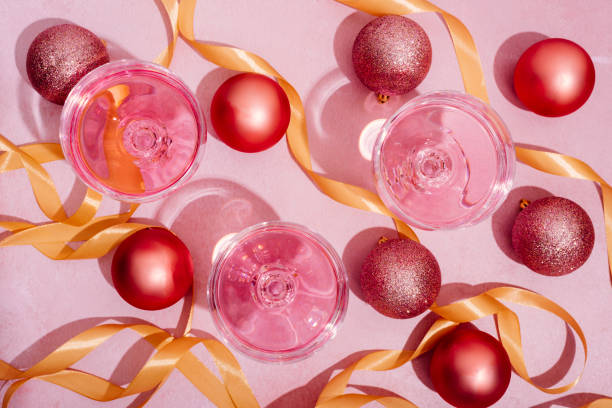 pink champagne in luxury crystal glasses and christmas baubles with golden ribbon decor. top view. new year eve celebration and nightclub party with girly drink toast. - champagne pink luxury table imagens e fotografias de stock