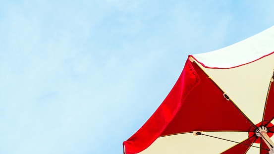 Umbrella beach. Red summer beach parasol on blue sea background. Sun sunshade for vacation travel. Outdoor relax holiday at ocean with copy space
