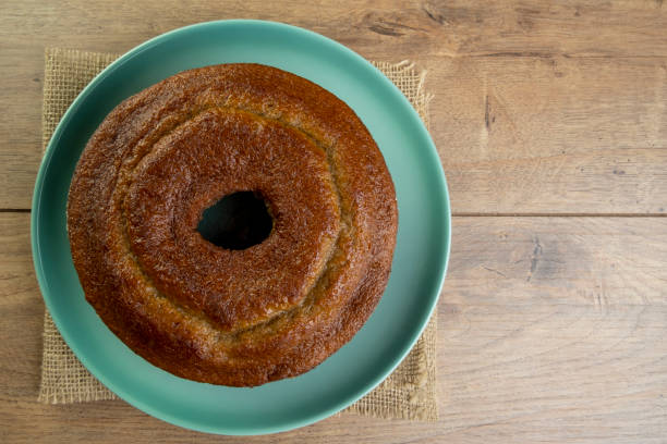 木製のテーブルの上に緑のプレートでバナナケーキ - baked brown cake circle ストックフォトと画像