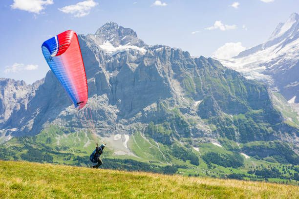 Hang glider start to fly between Swiss peaks. stock photo