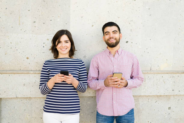 istock Smiling boyfriend and girlfriend texting 1356840337