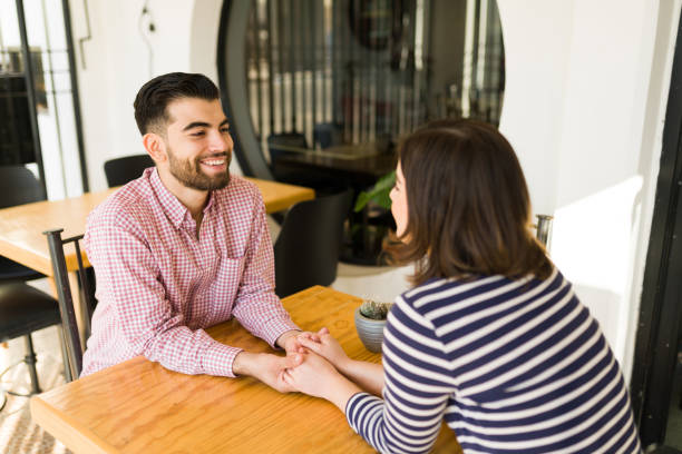 istock Loving couple holding hands at the cafe 1356840360