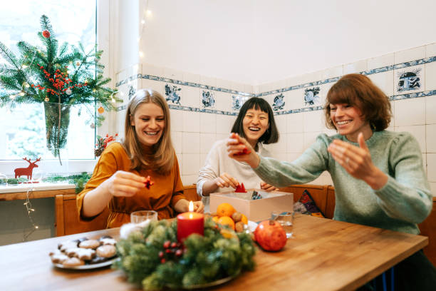 istock Women friends decorating dinner table for christmas eve 1356840678