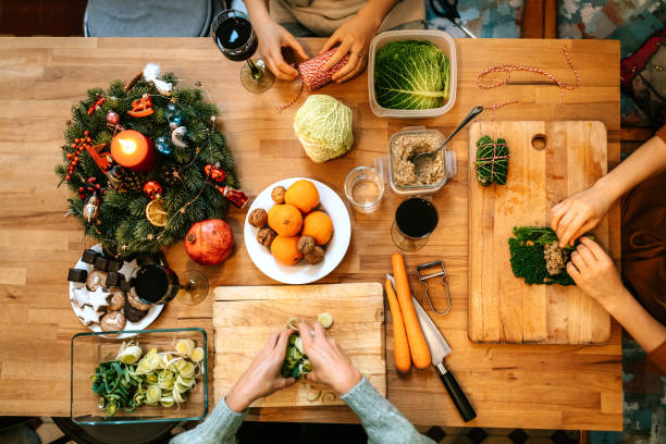 Females making christmas meal at decorated kitchen table