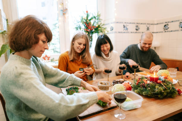 istock Friends making vegetarian christmas meal at decorated kitchen table 1356840818