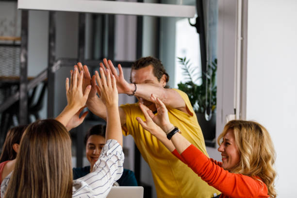 istock Coworkers doing a group high-five after successfully concluding a meeting 1356841679