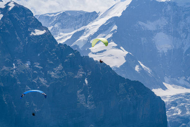 istock Hang glider fly between Swiss peaks. 1356841924