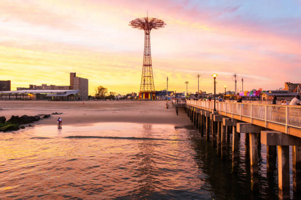 View of the Pat Auletta Steeplechase Pier, toward the Parachute Jump New York City, New York, United States of America - September 21, 2016. View of the Pat Auletta Steeplechase Pier, toward the Parachute Jump. View with people at dusk. odessa beach stock pictures, royalty-free photos & images