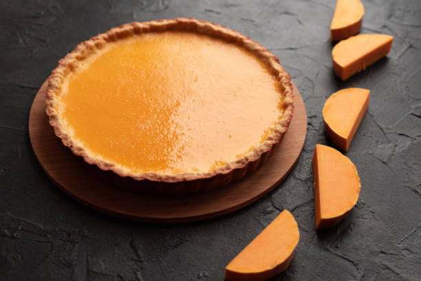 istock Pumpkin pie on dark background with squash slices 1356842666