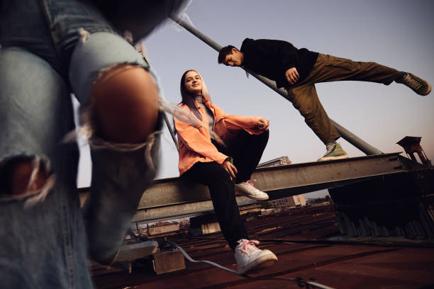 a teenagers hanging on rooftop and drinking beer. - generatie z stockfoto's en -beelden