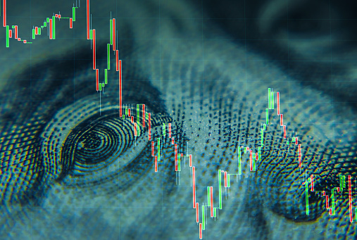 Hundred-dollar bills of American dollars and a portrait of Benjamin Franklin against the background of the dynamics of exchange quotations. Effective investment, business and finance concept