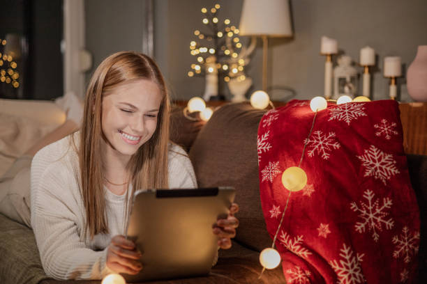 istock Young woman using digital tablet and enjoying cozy night at home 1356857339