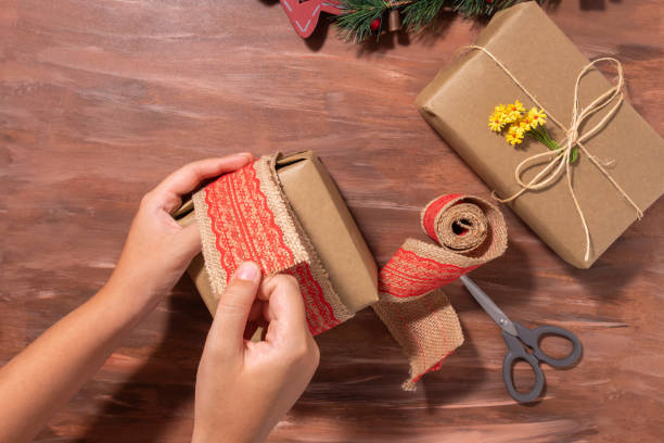 istock Hand holds gift, wooden background. 1356860493