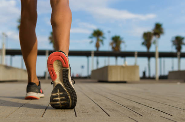 pernas de uma mulher com sapatos esportivos que está prestes a correr - determination unrecognizable person sport healthy lifestyle - fotografias e filmes do acervo