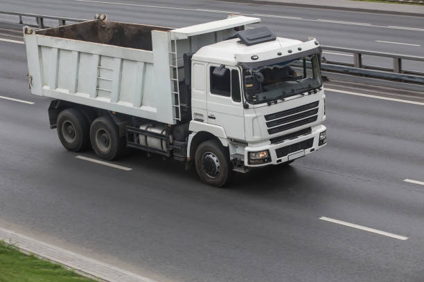 istock Dump truck driving on a multi-lane road 1356862102