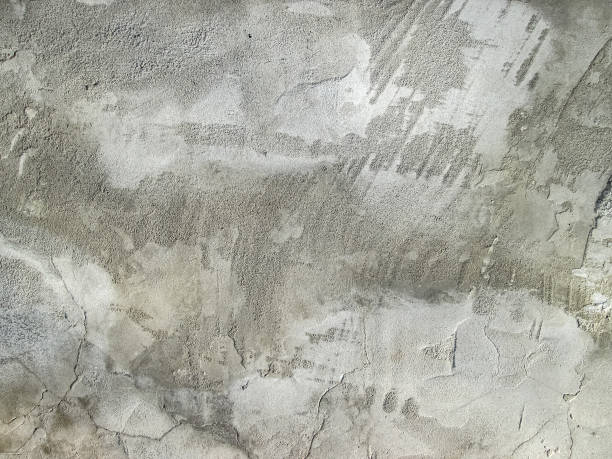 istock Stains on the smeared concrete surface. Stock gray background with roughness and grain. Abstraction with a frozen stone coating. 1356871957
