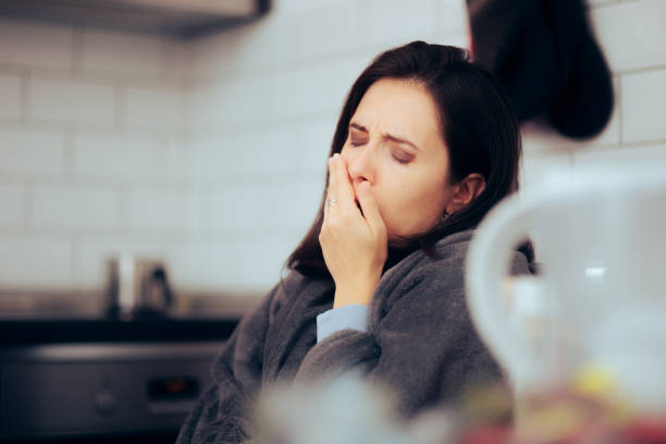 istock Tired Woman Sitting in the Kitchen Yawning Feeling Exhausted 1356874612