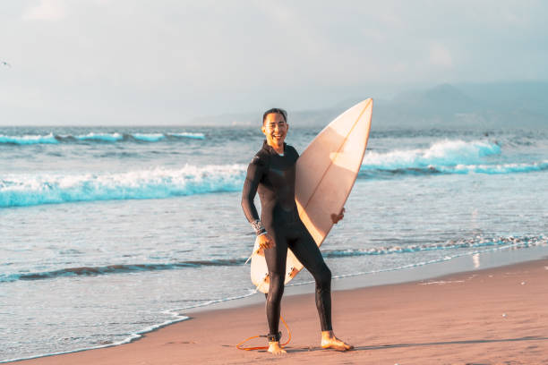 istock latin surfer on the beach with a surfboard 1356876319