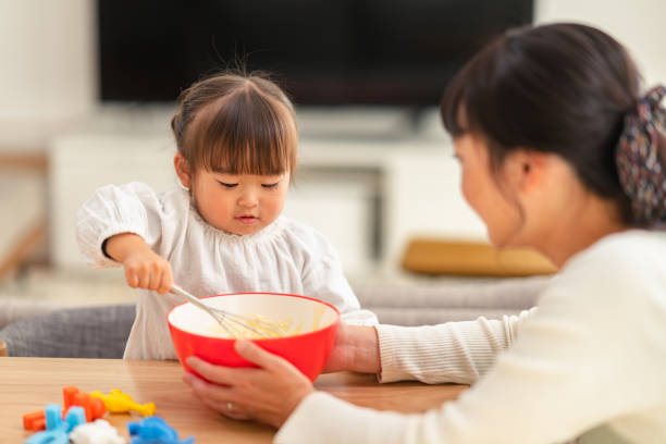 台所用品を使って彼女の小さな娘を教える母 - 母　娘　日本 ストックフォトと画像