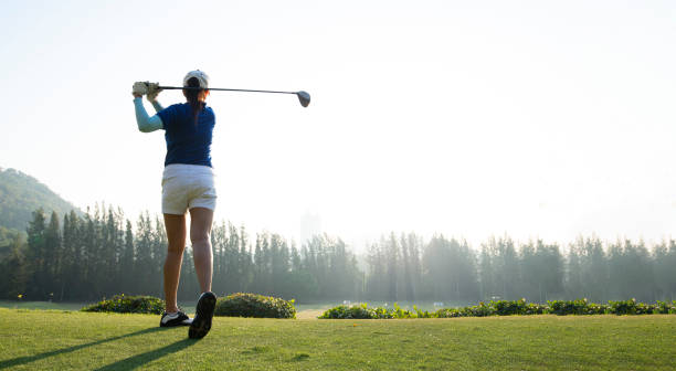 Young woman practices her golf swing on driving range, view from behind.Sport Concept Young woman practices her golf swing on driving range, view from behind.Sport Concept golf concentration stock pictures, royalty-free photos & images