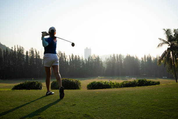 istock Young woman practices her golf swing on driving range, view from behind.Sport Concept 1356886044
