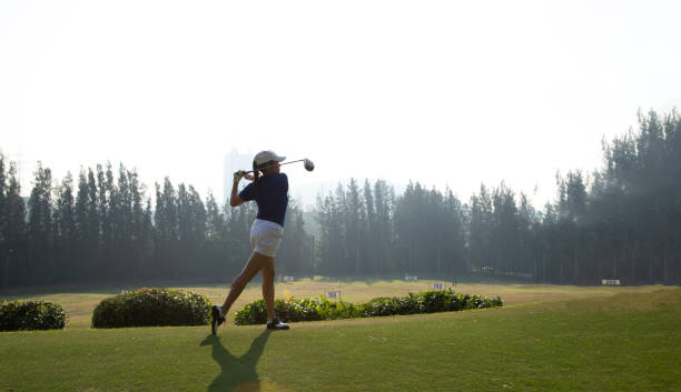 istock Young woman practices her golf swing on driving range, view from behind.Sport Concept 1356886052