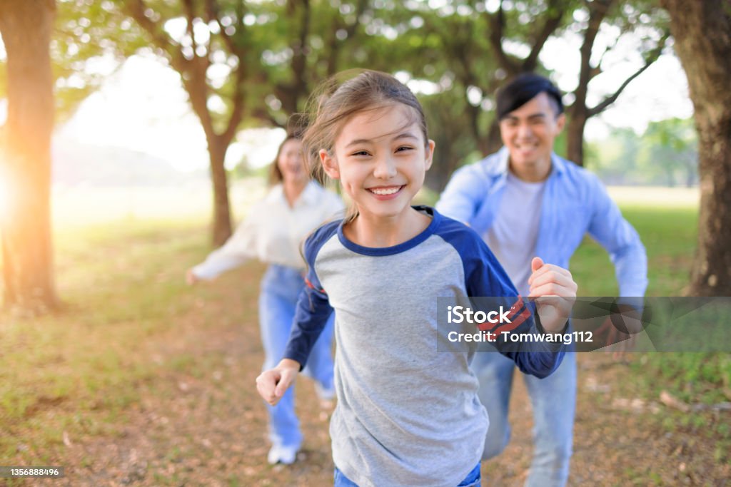 Happy Family  running and playing together in the park Family Stock Photo