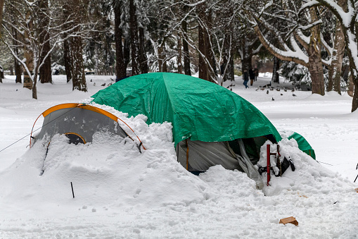 Homeless camping in the park after a winter snowfall.