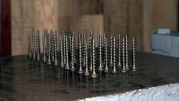istock Self-tapping screws on a metal plate are placed vertically in rows. 1356889651