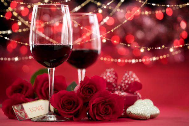 istock Valentine's Day Red Roses and Red Wine on a Defocused Lights Background 1356890212