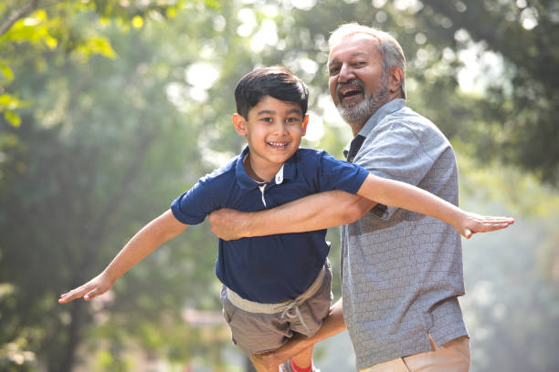 istock Playful grandfather lifting his grandson and helping him fly 1356894680