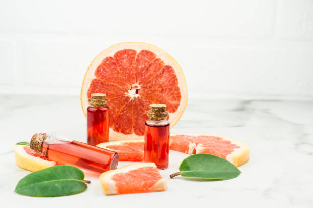 istock three glass bottles with a stopper with oil or grapefruit essence on a marble background with fruit slimes. the end of natural self-care. 1356896960