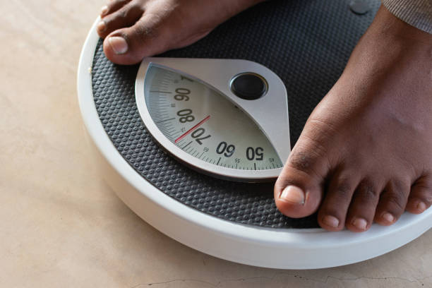 hombre en la báscula de peso para controlar el peso. concepto de dieta y pérdida de peso. - instrument of weight fotografías e imágenes de stock