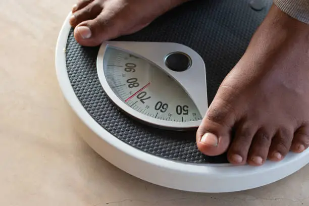 Photo of Male on the weight scale for check weight. Diet and weight loss concept.