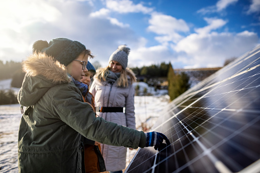 Mother and two little boys standing by solar panels and discussing about the sustainable technology. Sunny winter day.
Shot with Canon R5