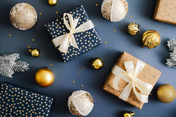istock Christmas flatlay composition. Elegant gift boxes and golden baubles on dark blue table. Flat lay, top view, overhead. Vintage style. 1356907391