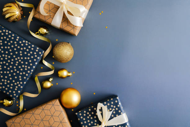 istock Christmas blue background with gift boxes, gold baubles, ribbon. Flat lay, top view, copy space. Merry Christmas and Happy New Year greeting card design. 1356907403